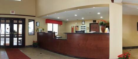 A reception area with a wooden reception desk, a red carpet, and a door marked "EXIT".