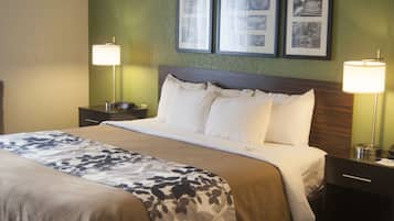 A neatly made bed with a floral bedspread, two bedside lamps, and framed pictures on the wall.