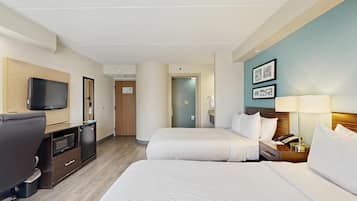 Habitació d'hotel amb dos llits, una taula de nit amb televisió, microones i un mini-frigorífic.