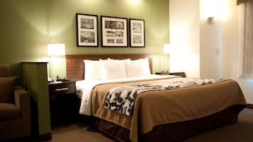 A hotel room with a bed, nightstands, a chair, and framed pictures on the wall.