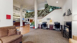 A spacious lobby with a staircase, a reception desk, and a fireplace. - Sleep Inn & Suites Buffalo Airport (Buffalo)