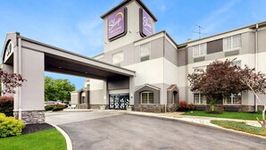 Un hotel Sleep Inn & Suites de diseño moderno, con una entrada destacada, un paseo techado y un césped bien cuidado.