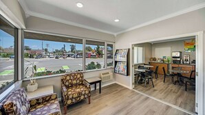 A hotel lobby with a seating area, a reception desk, and a view of the street. - Quality Inn Santa Cruz Downtown Area (Santa Cruz)