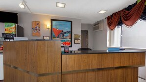 Una recepció amb acabat de fusta, un televisor de pantalla plana i un cartell a la paret.