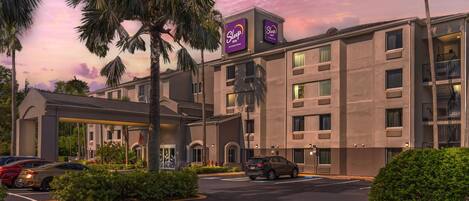 A hotel with a modern design, featuring a prominent Sleep In sign.