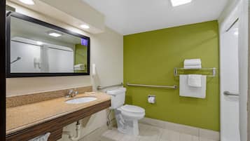 A bathroom with a sink, toilet, and a mirror.