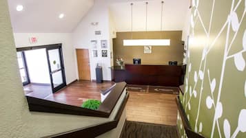 A hotel reception area with a reception desk, a reception counter, and a wall-mounted sign that reads "SLEEP INN".