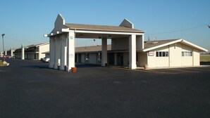A motel with a gas station canopy, multiple rooms, and a small office building. - Regency Inn Perrysburg (Perrysburg)