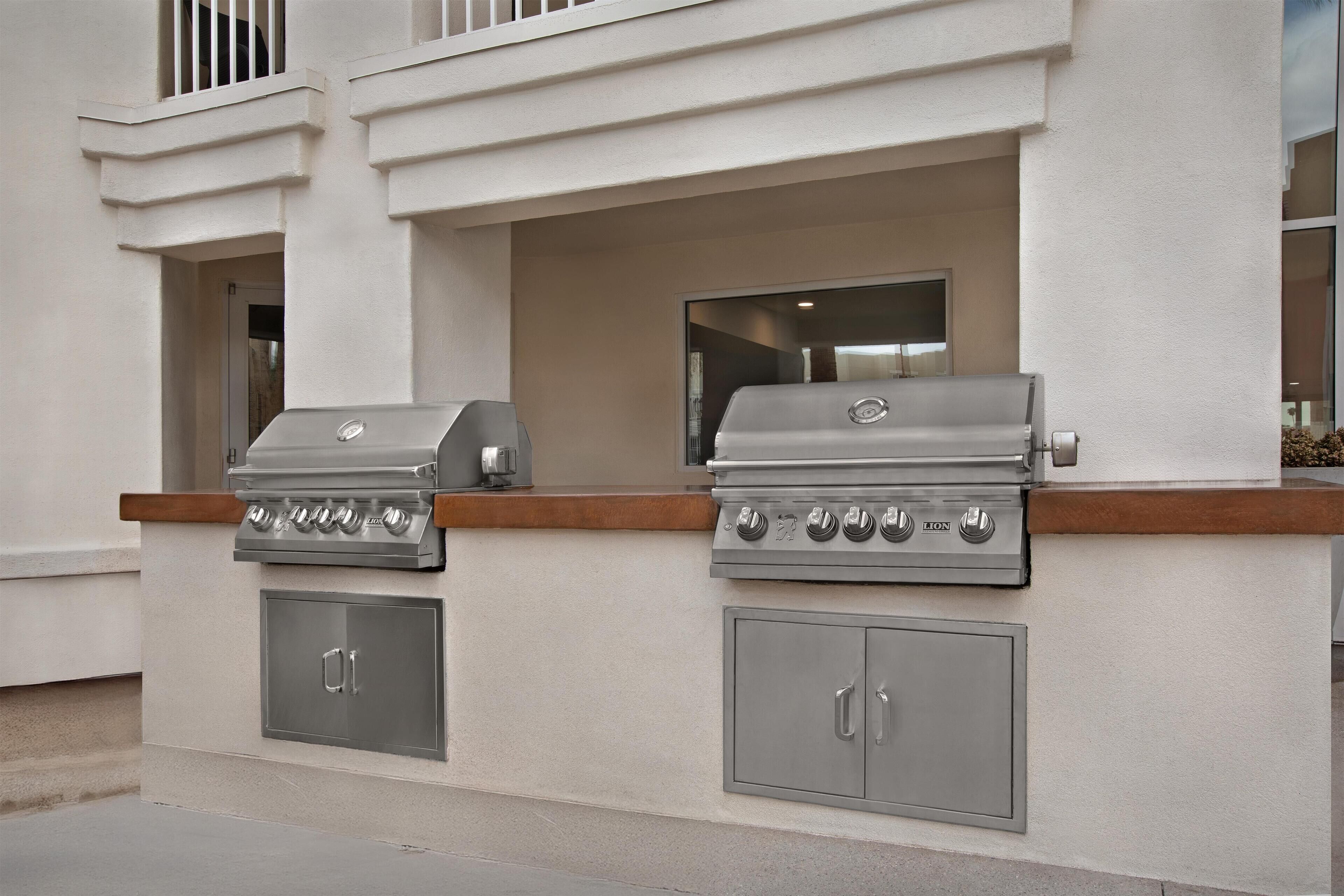 Cucina esterna con due barbecue a gas e pensili.