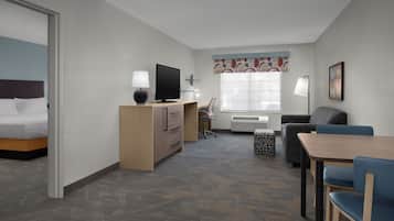 Ein Hotelzimmer mit Bett, Schreibtisch, Fernseher und Sitzecke.