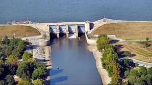 Un barrage doté d’un système d’écluses, entouré d’eau et de verdure.