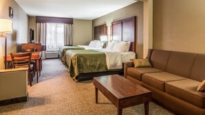 Une chambre d’hôtel avec un lit, un canapé, un bureau et une chaise.