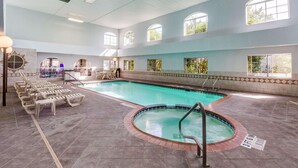 An indoor swimming pool with a hot tub, lounge chairs, and a sunlit room with a bar. - Quality Inn & Suites Kerrville (Kerrville)