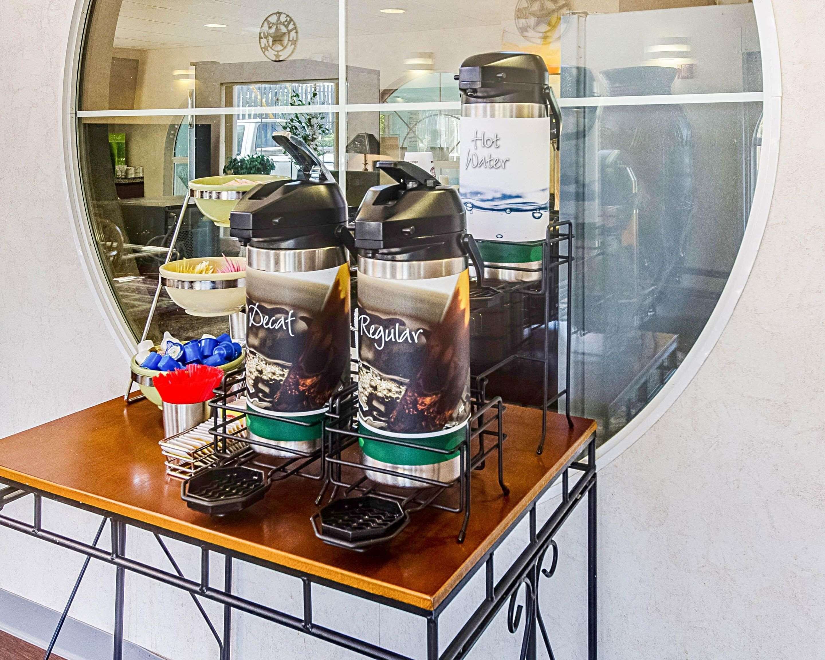A coffee machine with a 'Hot Water' sign, a 'Decaf' and 'Regular' label, and a 'Regular' coffee cup on a table.