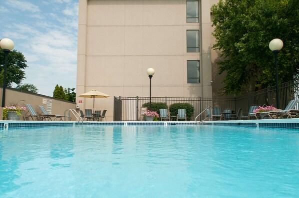 Una piscina al aire libre de temporada, sombrillas, tumbonas