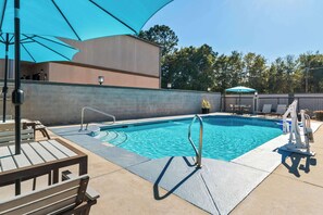 Una piscina al aire libre, tumbonas