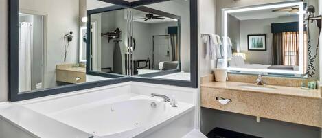 Une salle de bain moderne avec une grande baignoire sur pieds, un meuble-lavabo à deux vasques et un grand miroir.