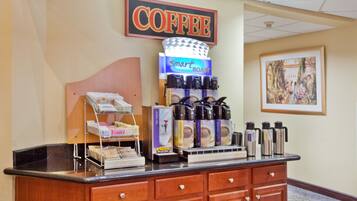 Un espace dédié au café, comprenant une machine à café, un présentoir de dosettes de café et un panneau indiquant « CAFÉ ».
