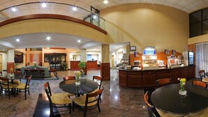 A spacious lobby with a high ceiling, a reception desk, a buffet area, and multiple seating arrangements. - Holiday Inn Express Hotel & Suites by IHG (Lawrenceville)