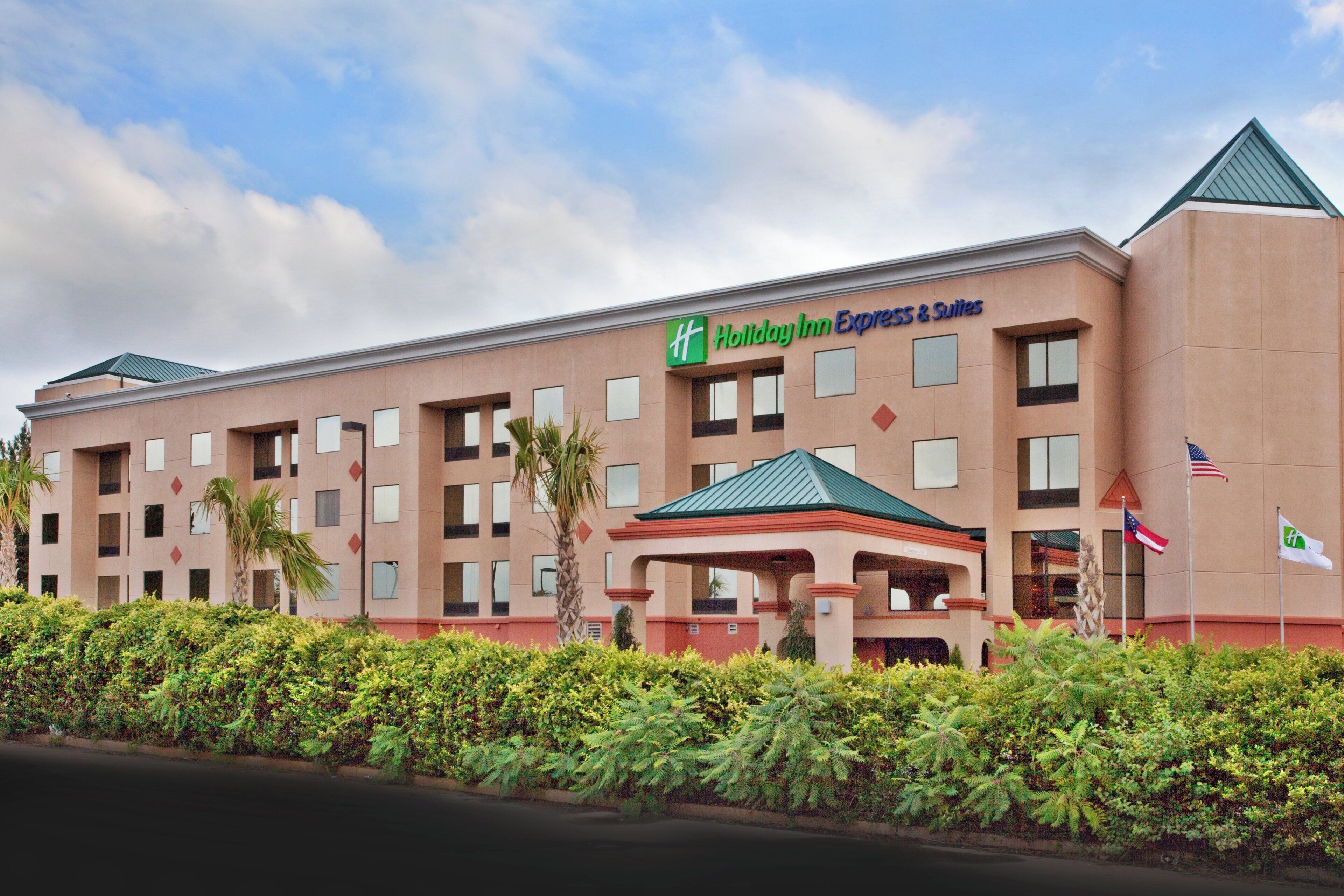 A Holiday Inn Express & Suites building with a flat roof, multiple windows, and a covered entrance.