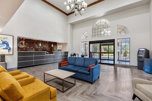 A spacious lobby with a reception desk, seating area, and an ATM machine. - Comfort Inn & Suites Perry National Fairgrounds Area (Perry)