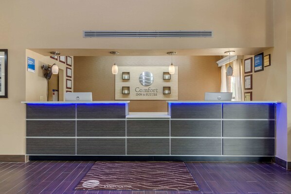 A hotel reception desk with a modern design, featuring a logo, a digital screen, and a reception counter. - Comfort Inn & Suites Perry National Fairgrounds Area (Perry)