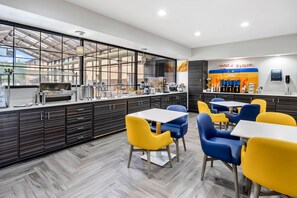 A modern cafe with a glass enclosure, a coffee bar, and seating areas. - Comfort Inn & Suites Perry National Fairgrounds Area (Perry)