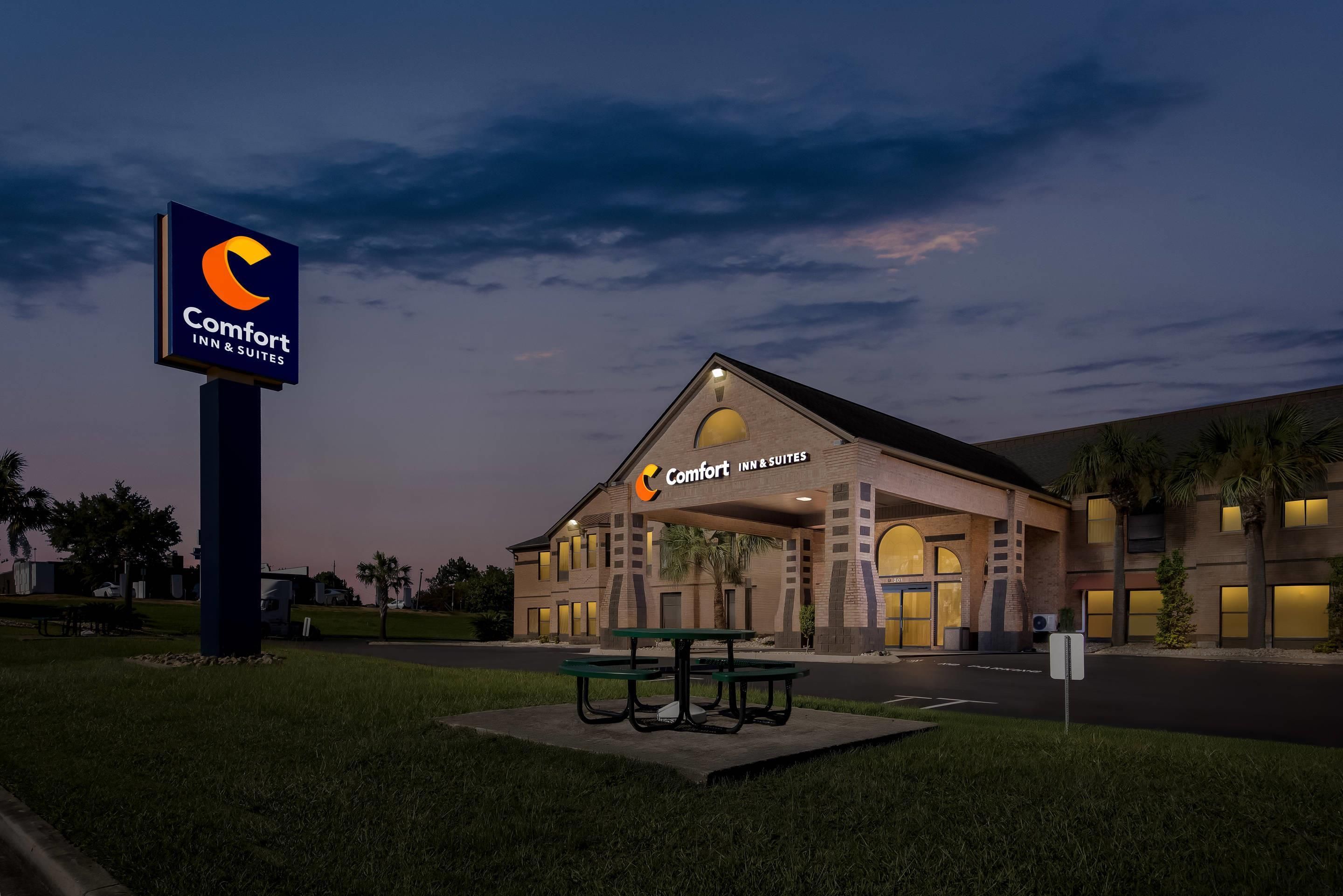A Comfort Inn & Suites hotel with a prominent sign, a covered entrance, and a parking area.