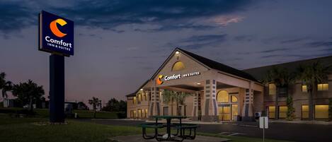 Een Comfort Inn & Suites hotel met een opvallend bord, een overdekte ingang en een parkeerplaats.