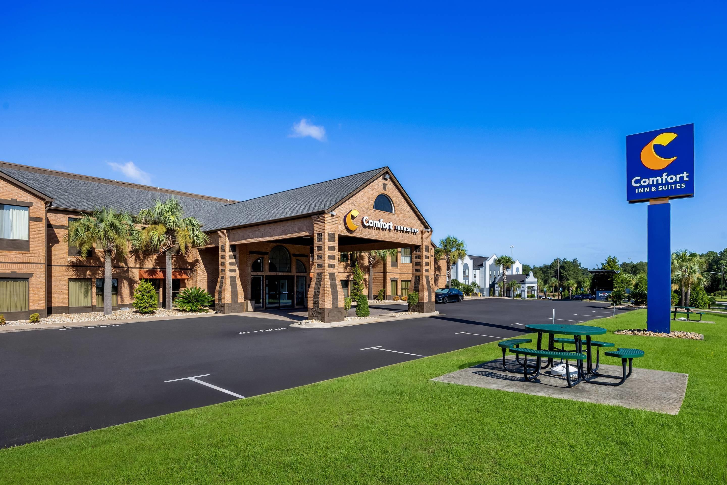 A Comfort Inn & Suites with a brick facade, a covered entrance, and a parking lot.