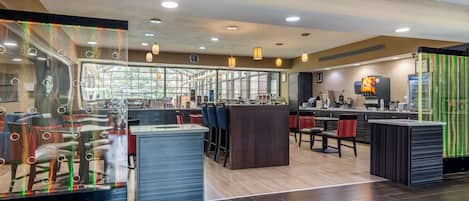 A modern restaurant with a bar area, seating, and a large window offering a view.