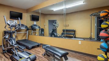 A gym with treadmills, a stationary bike, a bench, and exercise balls.