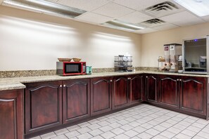 A kitchen with a microwave, toaster, and coffee maker on the counter.