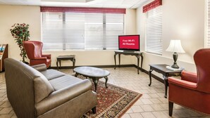 Una sala moderna con un sofá, sillones, una mesa de centro y un televisor.