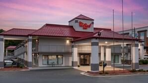 A Red Roof Inn with a red roof, a covered entrance, and a sign above the entrance.