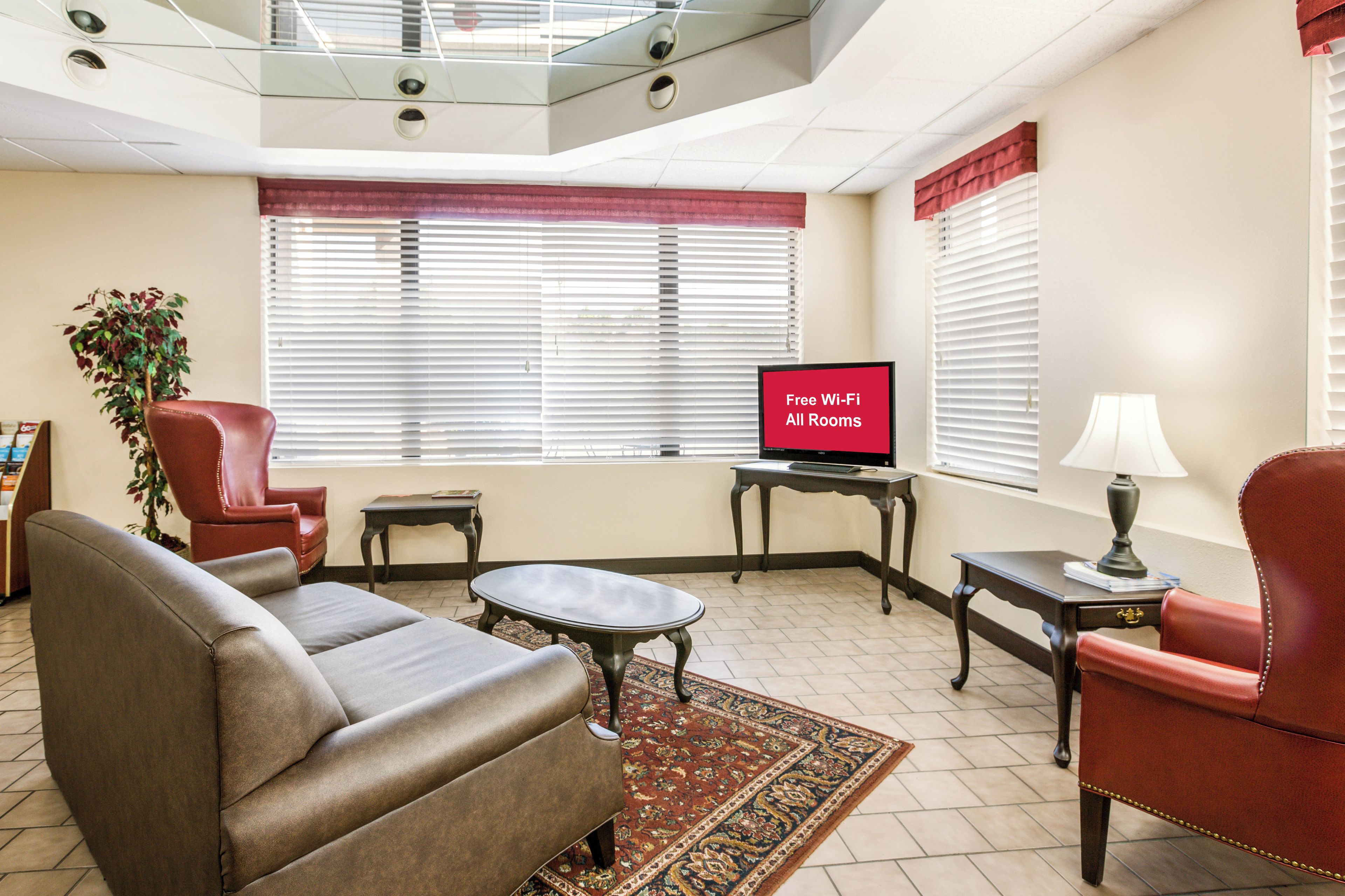 A living room with a sofa, armchair, TV, and a small table.