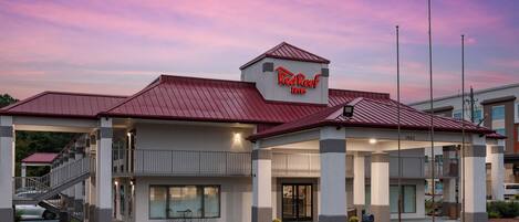 Un RedRoof Inn con techo rojo, entrada cubierta y una estructura de dos pisos.