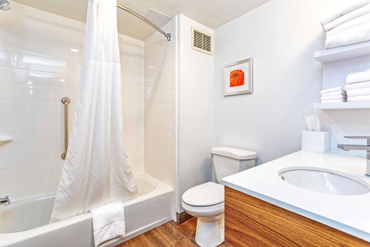 A modern bathroom with a shower, toilet, and sink.