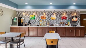A modern kitchen with a central island, wooden cabinets, and a tiled backsplash. - Quality Inn Cadiz (Cadiz)
