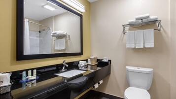 A modern bathroom with a black sink, mirror, white toilet, and towel rack.