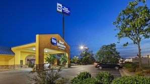 A Best Western Inn & Suites with a prominent sign, a parking lot, and surrounding greenery. - Best Western Inn & Suites (Byron)
