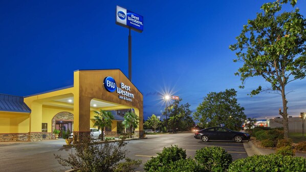 A Best Western Inn & Suites with a prominent sign, a parking lot, and surrounding greenery.