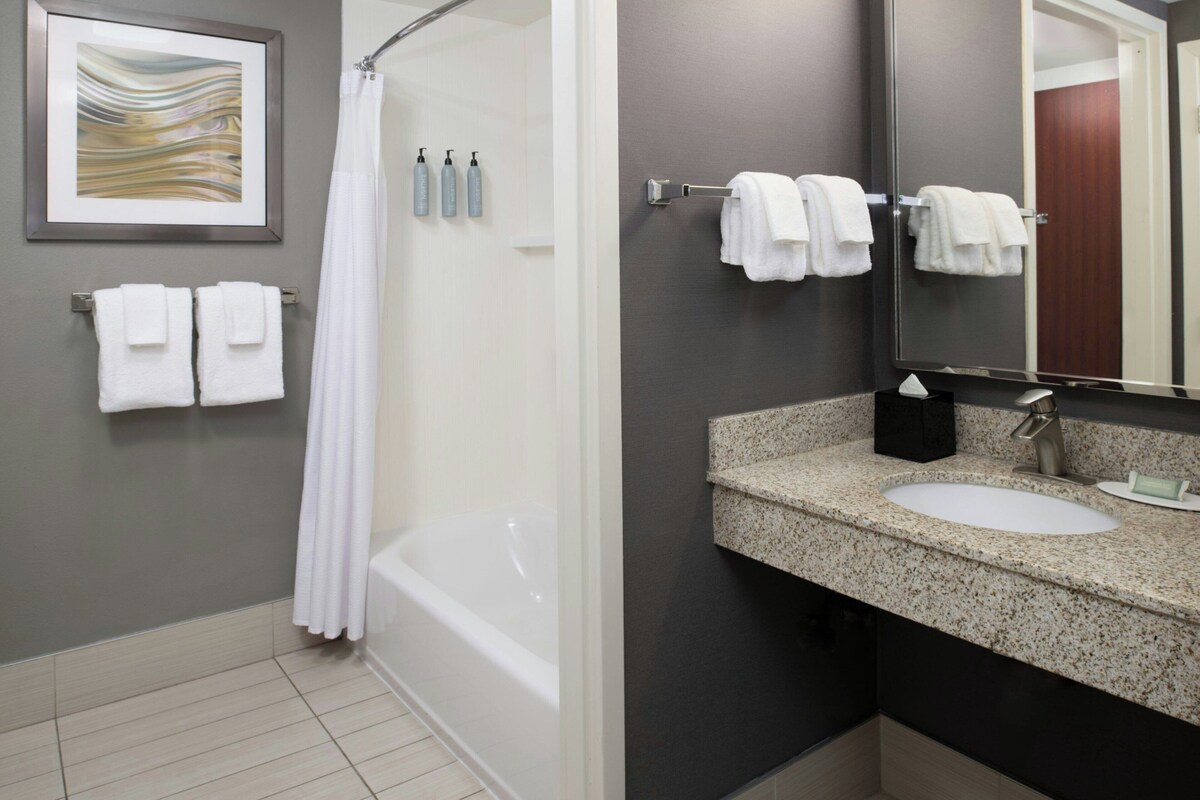 Une salle de bain moderne équipée d’une baignoire, d’une douche, d’un lavabo et d’un miroir.