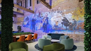 Un área de descanso con asientos cómodos, un mural de músicos y un fondo de pared de ladrillo.