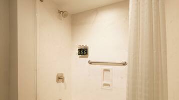 A modern bathroom with a freestanding bathtub, a glass shower enclosure, and a marble-tiled floor.
