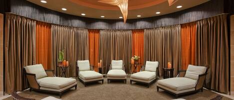 A conference room with a semi-circular arrangement of chairs, a carpeted floor, and a backdrop of curtains.