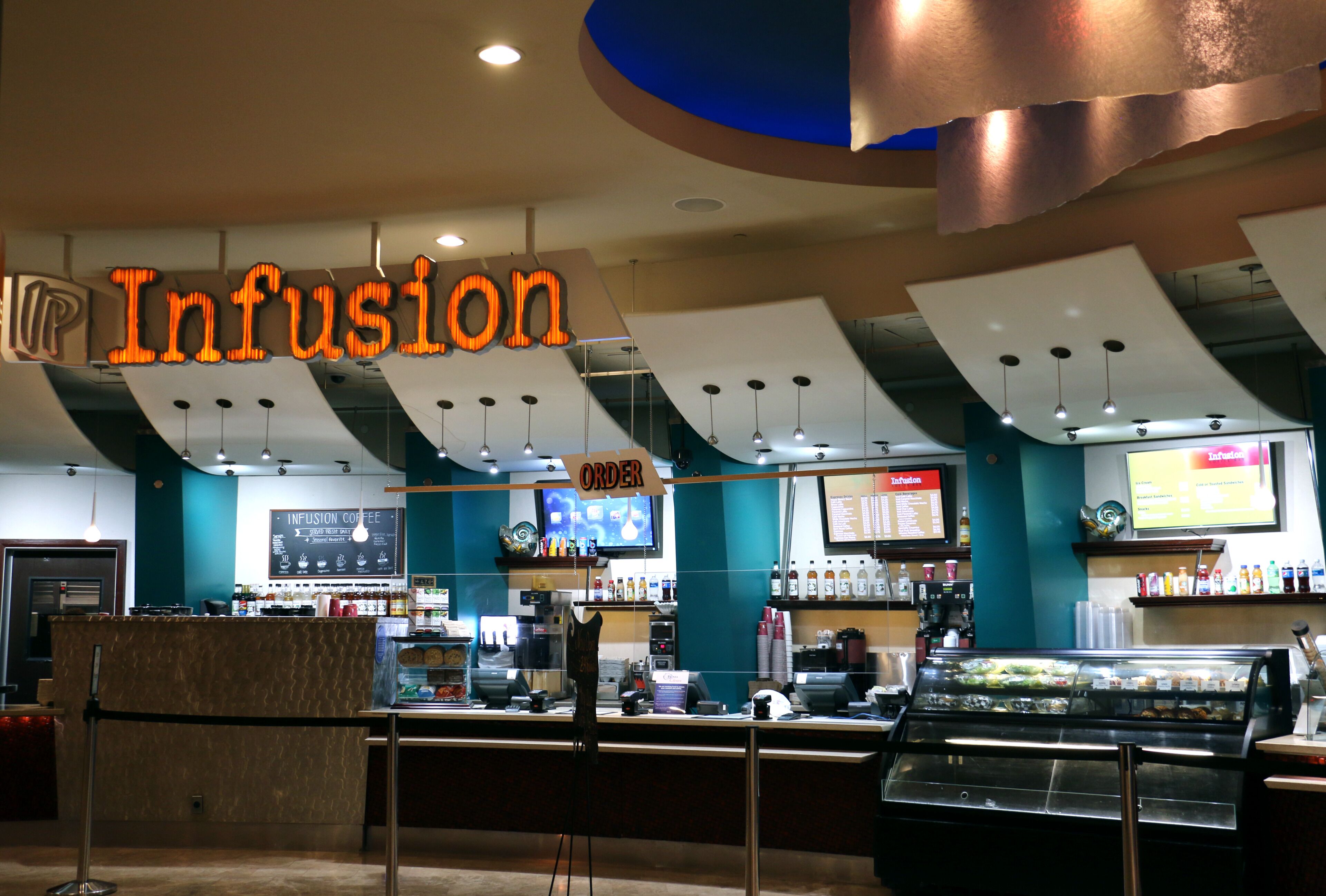 A coffee shop interior with a counter, menu boards, and a coffee display.