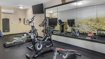 A gym with stationary bikes, treadmills, and a bench.