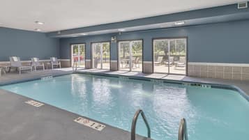 Una piscina techada, sillones reclinables de piscina