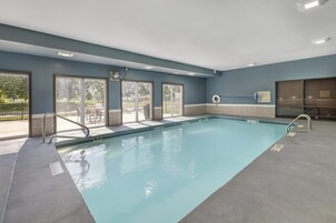 Una piscina techada, sillones reclinables de piscina